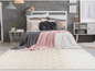Tapis beige avec motif blanc dans une chambre à coucher avec un lit blanc et une couverture rose