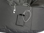 Un pouf gris avec une poche, un téléphone et des écouteurs.
