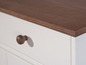Une commode blanche avec un plateau en bois brun.