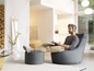 Un homme écoute de la musique dans un fauteuil beanbag gris.