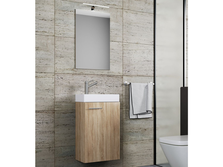 Un meuble de salle de bain avec un lavabo, un miroir et un porte-serviettes.