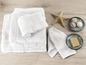 Pile de serviettes de bain, serviettes et un savon sur une surface en bois.