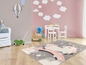Une chambre d'enfant avec un tapis rose avec une licorne
