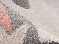 Un tapis doux, rose et gris avec des motifs géométriques.