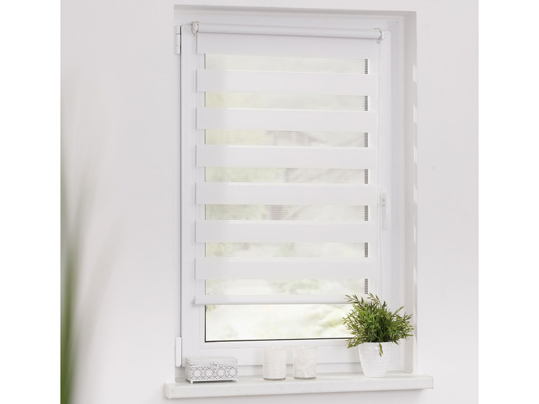 Des stores blancs avec une texture transparente, installés sur une fenêtre.