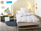 Couette et oreillers Fjodur sur un lit avec draps blancs.