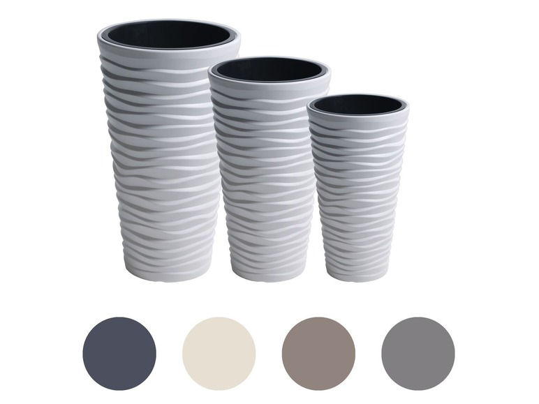 Trois pots de fleurs blancs ondulés de différentes tailles.