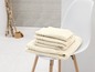 Une pile de serviettes sur une chaise blanche.