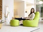 Une femme se détend dans un pouf vert Sitting Bull.