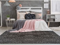 Un tapis gris avec un motif géométrique dans une chambre à coucher avec un lit blanc.