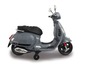 Un scooter Vespa électrique gris pour enfants avec des roues d'entraînement.