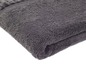 Une serviette de bain gris foncé pliée sur un fond blanc.