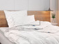 Une couette et des oreillers blancs sur un lit.