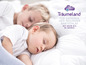 Deux enfants dorment dans un lit, avec le logo de Träumeland.