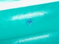 Une piscine gonflable turquoise avec une valve.