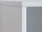 Détail d'une bibliothèque blanche avec des étagères.