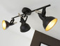 Trois lampes de plafond noires ajustables.