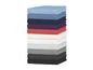 Une pile de draps de lit de différentes couleurs.