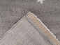 Détail d'un tapis gris avec une bordure beige.