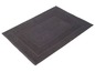 Un tapis de bain gris foncé avec une bordure décorative.