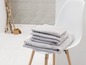 Serviettes empilées sur une chaise blanche.