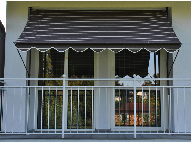 Un store rayé au-dessus d'un balcon avec une balustrade blanche