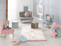 Deux petits fauteuils en velours, un pouf et un tapis pour une chambre d'enfant.