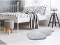 Un lit blanc avec un tapis gris moelleux dans une chambre moderne.