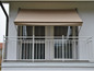Un auvent beige au-dessus d'un balcon avec une balustrade blanche.