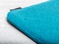 Un coussin chauffant en laine turquoise.