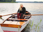 Une femme et son chien dans un bateau sur un lac.