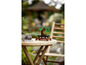 Un bonsaï LEGO sur une table en bois dans un jardin.