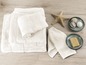 Une pile de serviettes de bain, deux serviettes, du savon et des produits de bain.