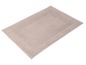 Tapis de bain beige avec bordure brodée.