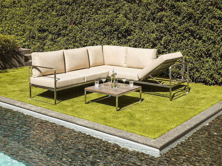 Un canapé d'angle moderne en extérieur avec une table basse, dans un jardin au bord d'une piscine.