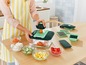 Une femme utilise une mandoline pour couper des légumes.