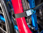 Un vélo rouge avec une sangle noire et une boucle.