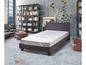 Un lit avec un protège-matelas dans un intérieur moderne.