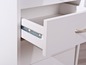 Une commode blanche avec un tiroir ouvert.