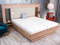 Un lit en bois avec un matelas et une table de chevet.