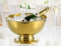 Un seau à champagne doré avec une bouteille de champagne et de la glace.
