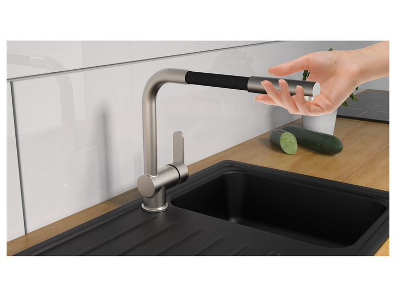 Un robinet de cuisine moderne avec un évier noir.