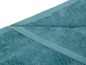 Une serviette de bain pliée de couleur bleu clair.
