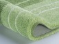 Un tapis de bain vert doux avec un revêtement antidérapant.