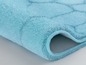 Un tapis de bain bleu clair avec une couche antidérapante.