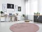 Un tapis rond rose dans une pièce moderne avec un bureau et une étagère.