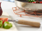 Un dessous de plat en cuivre avec une casserole dessus.
