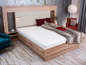 Un lit en bois avec un matelas et une couverture.