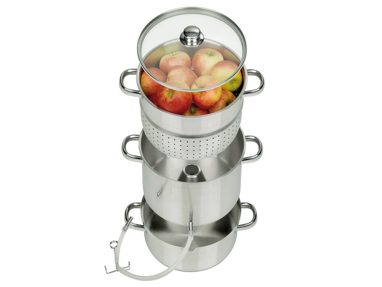 Une presse à jus en acier avec des pommes pour faire du cidre de pomme.