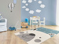 Une chambre d'enfant avec un tapis d'ours gris et blanc sur un fond bleu.